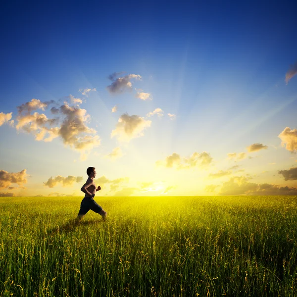 Sunset and running young man — Stock Photo, Image