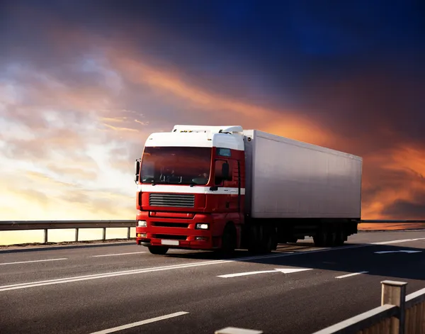 Ciężarówki na autostradzie i zachód słońca — Zdjęcie stockowe