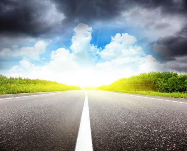 Road black clouds and sun Royalty Free Stock Images