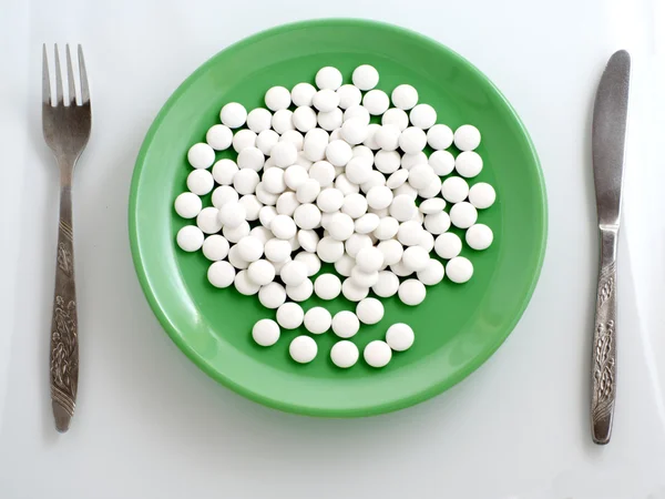 Pills on green plate — Stock Photo, Image