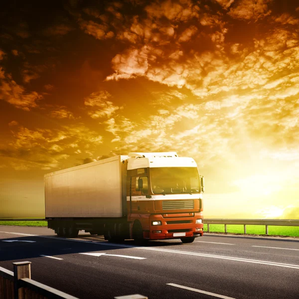 Vrachtwagen op de snelweg en zonsondergang — Stockfoto