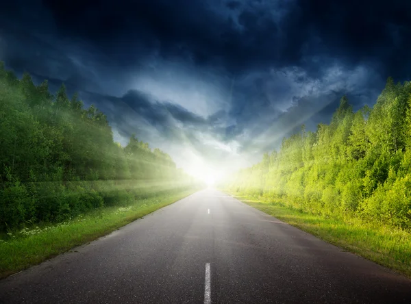 Stormy sky and road in forest Royalty Free Stock Images