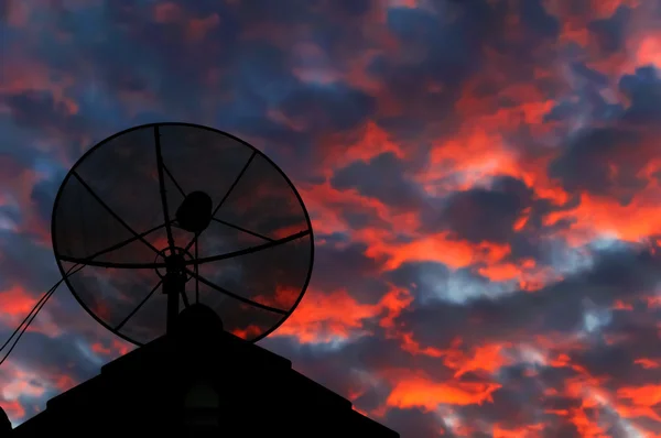 Uydu çanağı siluet akşam gökyüzünde çatıda. — Stok fotoğraf