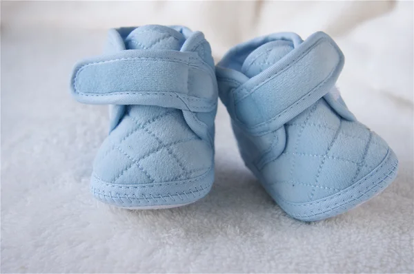 stock image Blue children's bootees on a white plaid