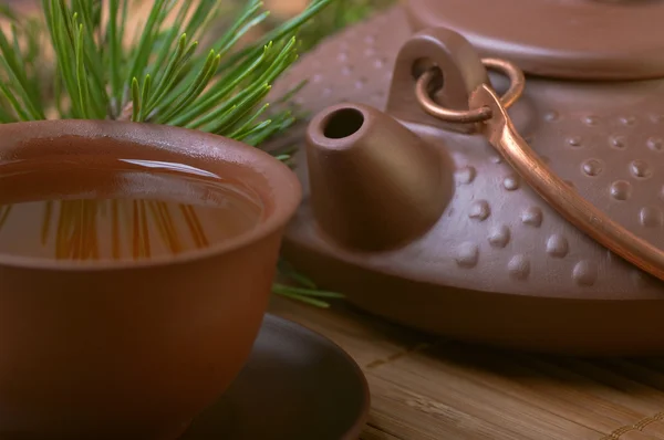 Ceramic teapot with a cup of tea