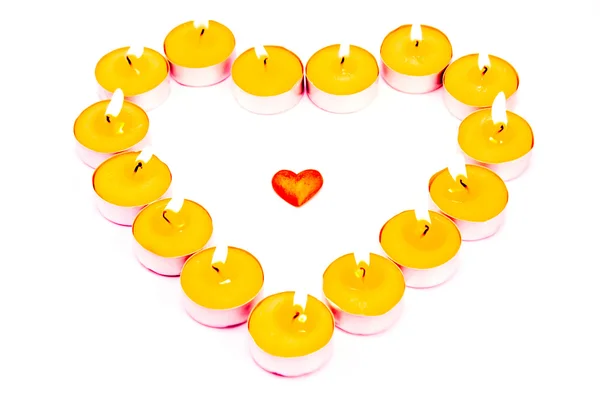 Сердце, окруженное горящими свечами — стоковое фото