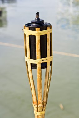 Bamboo torche near water clipart