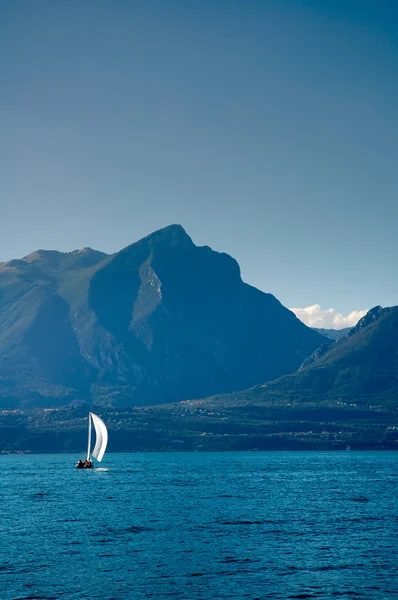 Ιστιοφόρο Στο Λίμνη Garda Βουνά Στο Πίσω Μέρος Εικόνα Αρχείου