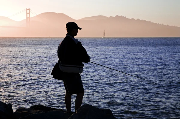 Человек Рыбачит Заливе Сан Франциско Мостом Золотые Ворота Заднем Плане — стоковое фото