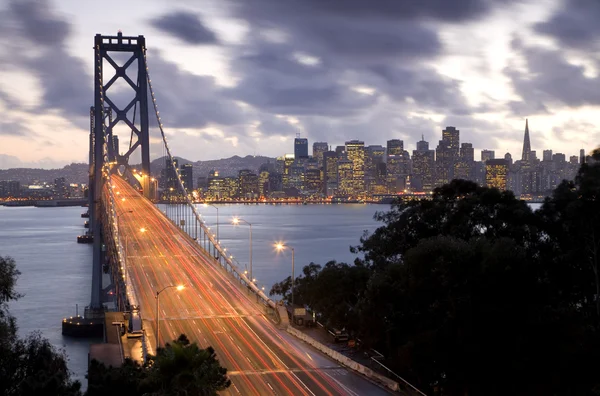 夕暮れブルーバックで宝物島 サンフランシスコから湾橋上のトラフィックの時間の露出画像 ストックフォト