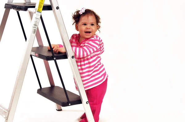 Baby standing by a ladder — Stock Photo, Image