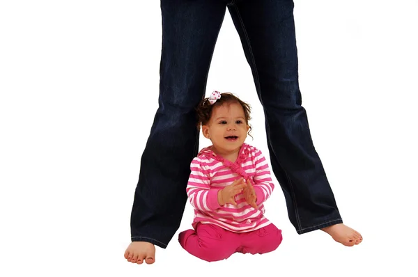 Baby sitting beneath mommy's legs — Stock Photo, Image