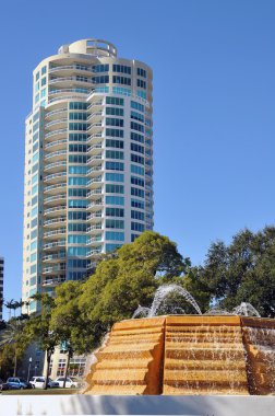 View of a modern condo skyscraper with a fountain in the foreground in tropical St. Petersburg, Florida. clipart