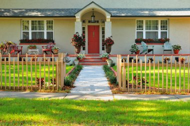 Entryway of a meticulously kept home, with colums, walkway, fence and beautiful landscaping, making this a desirable place to live. clipart