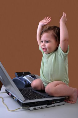 Baby with laptop and arms in air clipart
