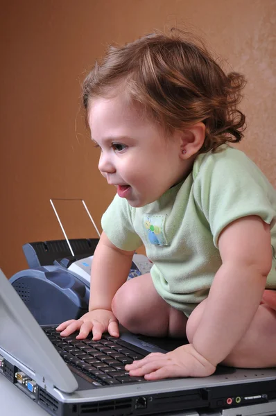 Baby sitting ON the laptop smiling — Stock Photo, Image