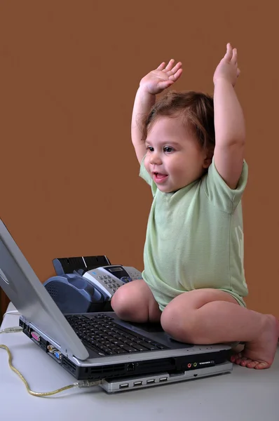 Baby mit Laptop und Armen in der Luft — Stockfoto