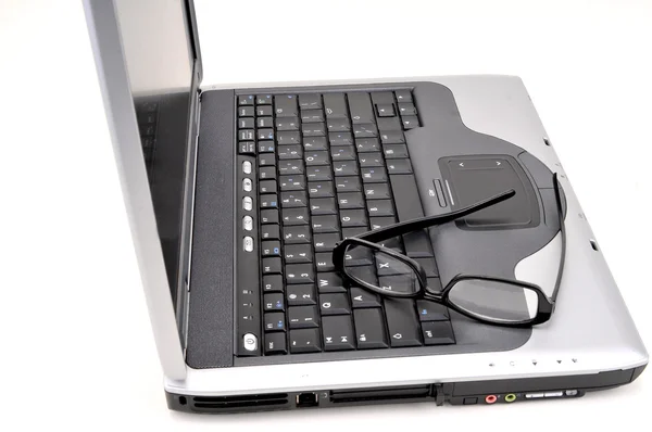 Открытый ноутбук с черными очками — стоковое фото