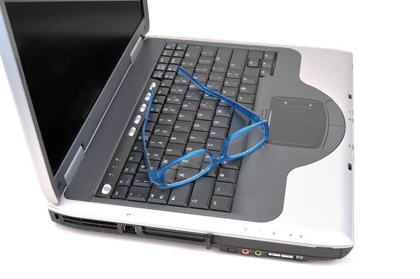 Niebieski okulary siedzi na laptopie — Zdjęcie stockowe
