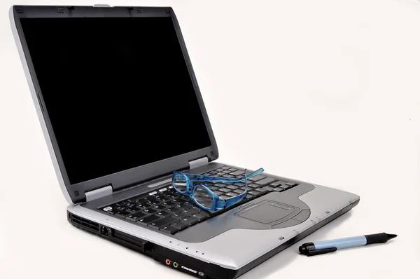 Laptop med glasögon och penna — Stockfoto