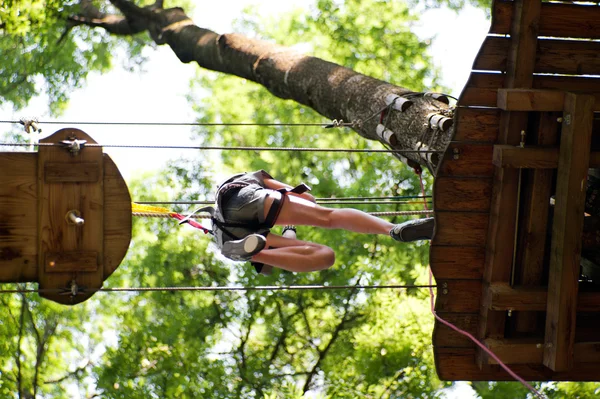 Stock image Woman jumps high up on a wooden platform