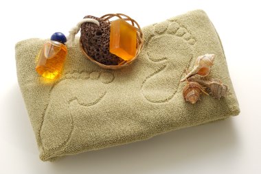 Beige foot SPA set with soap, pumice and shells on towel with footprints clipart