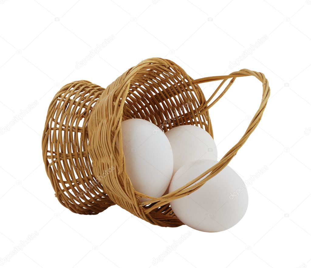 Three white eggs spilled from straw interwoven basket