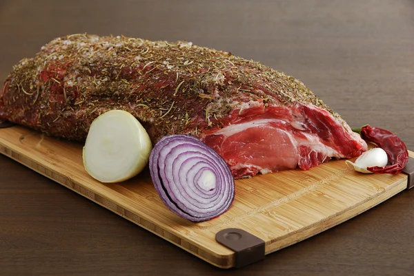 Целый кусок сырого мяса со специями, готовыми к приготовлению — стоковое фото