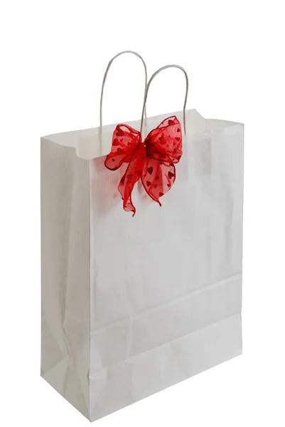 White paper gift bag with red ribbon — Stock Photo, Image