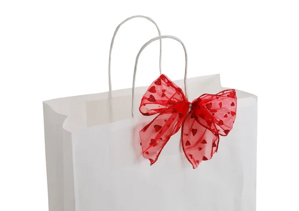 Gros plan de sac cadeau en papier blanc avec arc rouge — Photo