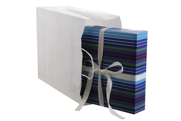 Подарок, завернутый в полосатую голубую бумагу, торчащую из белой ба — стоковое фото