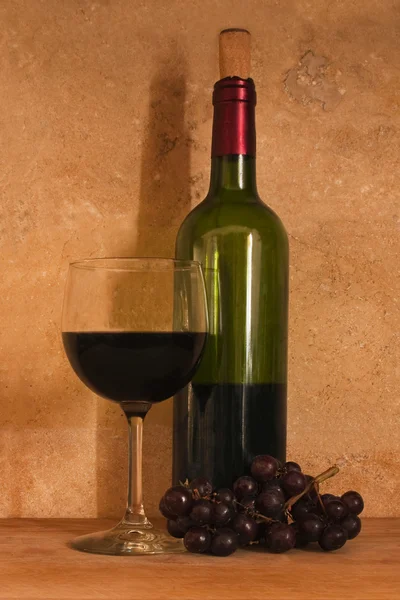 Ένα Ποτήρι Κόκκινο Κρασί Και Ένα Μπουκάλι Κρασί Κόκκινα Σταφύλια — Φωτογραφία Αρχείου