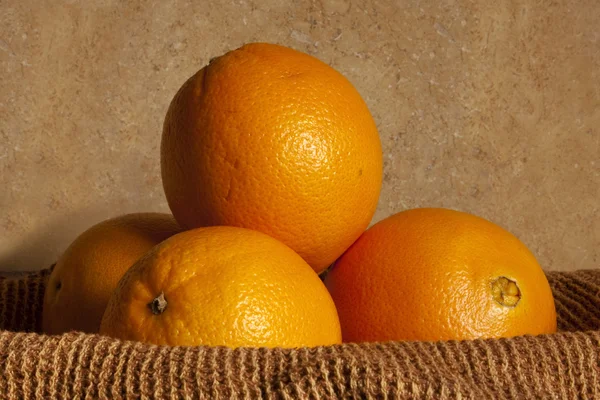 Eine Anordnung Von Vier Orangen Einem Mit Tuch Drapierten Korb Stockbild