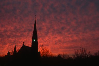 bir kilise ve çan kulesi, silüeti için zemin oluşturan dramatik gündoğumu