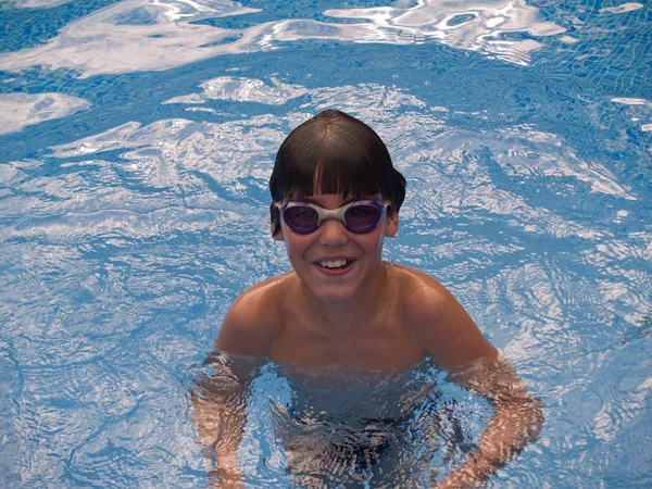 青いプールで泳いでいる少年 — ストック写真