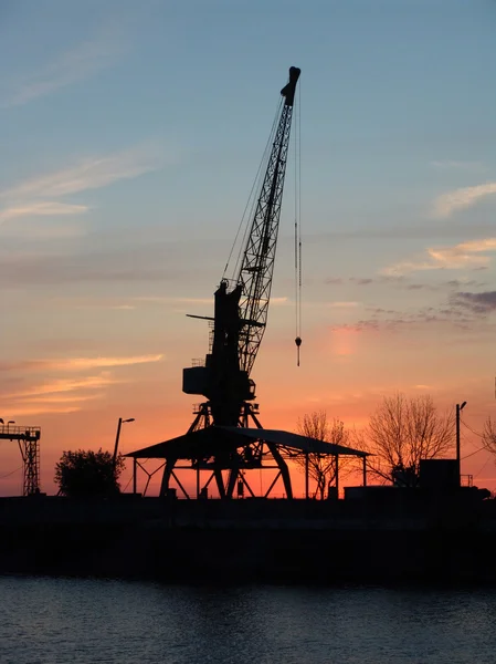 stock image Silhouette of a port crane at sunset