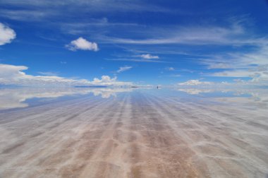 View across flooded Salar de Uyuni towards Salt Hotel clipart