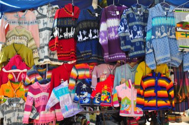 Woollen jumpers on market stall clipart