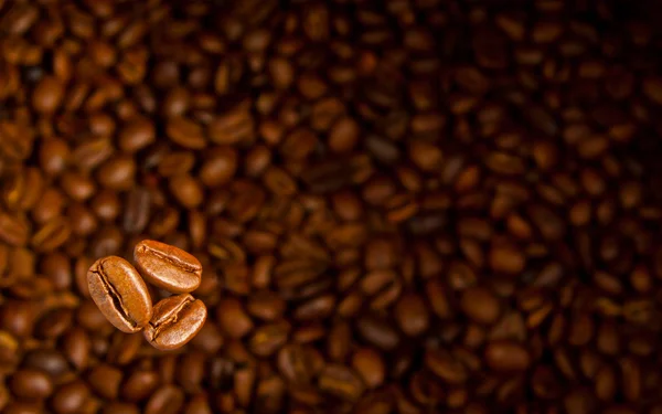 Coffeethree Koffie Korrels Een Dim Achtergrond Van Koffie — Stockfoto