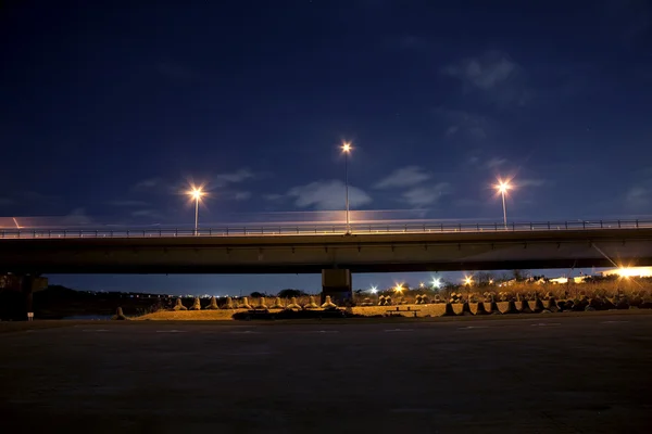 橋の車の来る夜と光を行く ロイヤリティフリーのストック画像