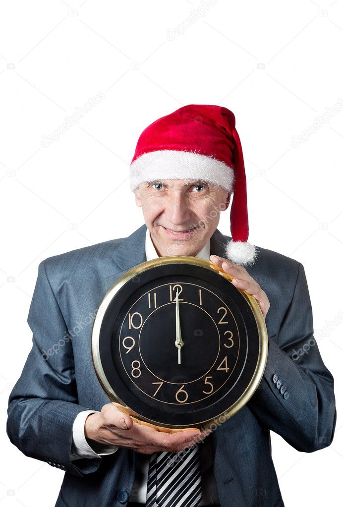 Old man in Christmas hat holding a big clock isolated on white
