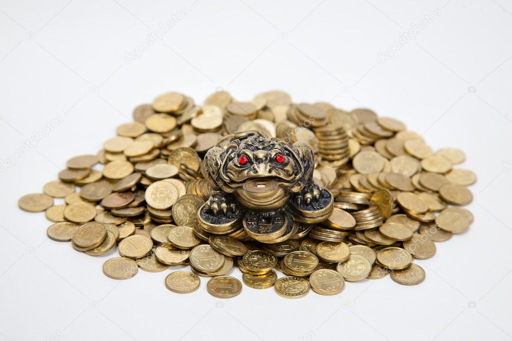 Feng Shui Frog sitting on the heap of Kazakh coins at white background
