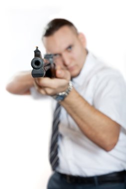 Businessman with gun is aiming. Focus on the barrel. White background. clipart