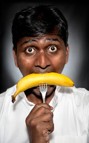 Indian man eating banana — Stock Photo, Image