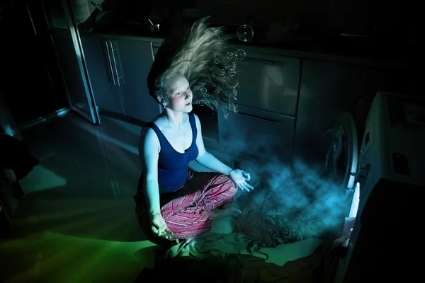 Женщина рядом со стиральной машиной под водой — стоковое фото