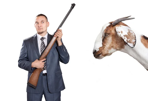 Geschäftsmann mit Waffe schaut Ziege an — Stockfoto