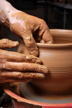 Hands of a potter, creating an earthen jar on the circle clipart