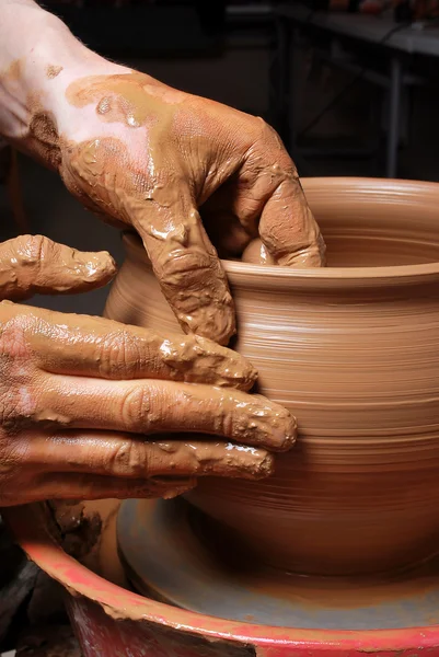 陶工的手 在圆周上制造一个陶罐 图库图片