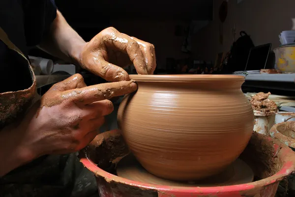 陶工的手，在圆周上制造一个陶罐 免版税图库图片