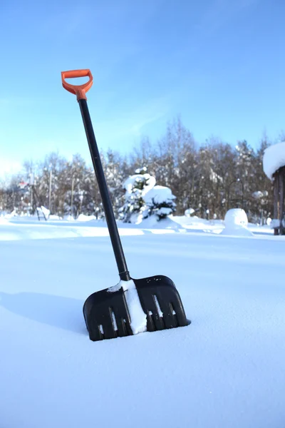 黑色雪铲用黄色柄根棍子在雪中 — 图库照片